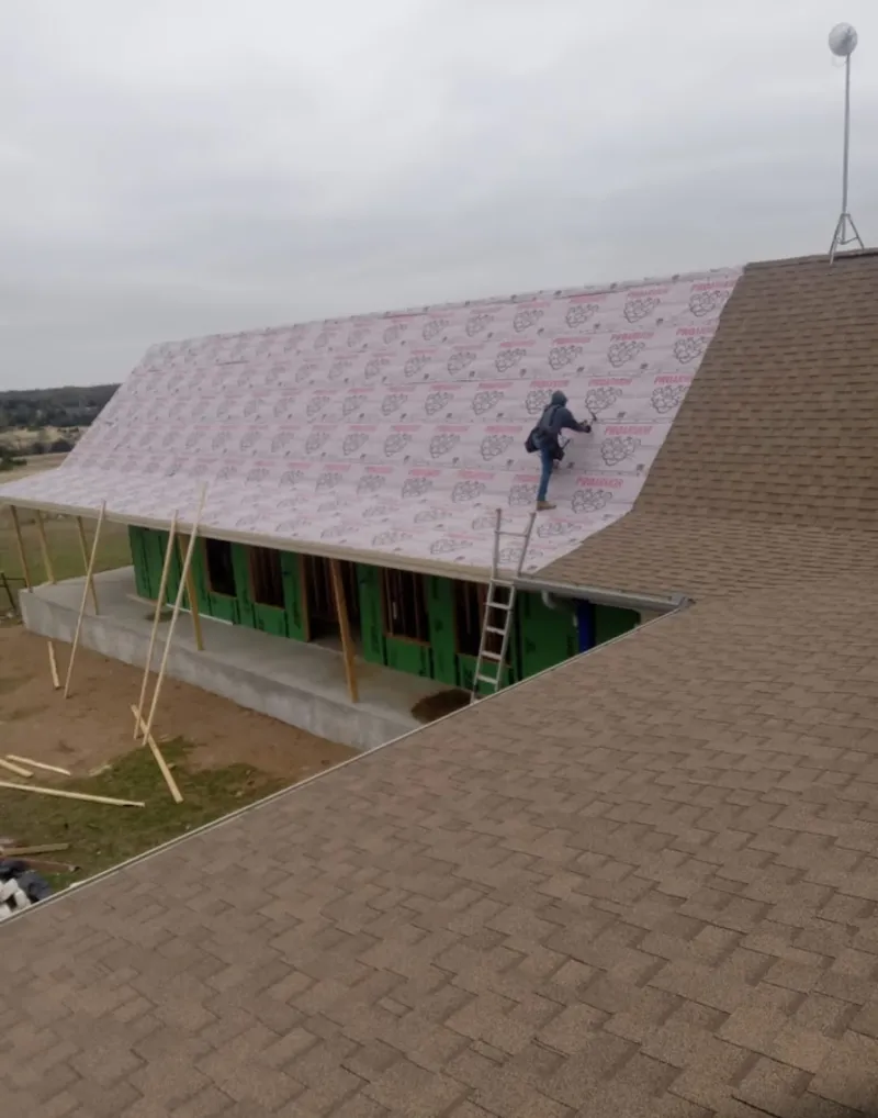 Worker preparing underlayment for a metal roof installation in Citrus Park